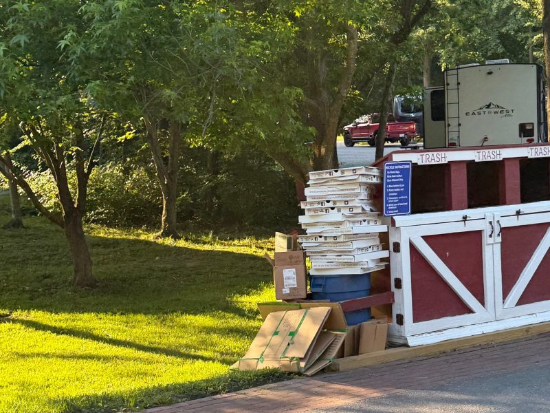 Stacks of pizza boxes by the trash station after an RV caravan group dinner at Cherry Hill Park