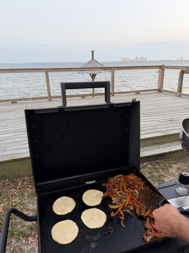 Fajita peppers and tortillas on a griddle at our campsite overlooking the water