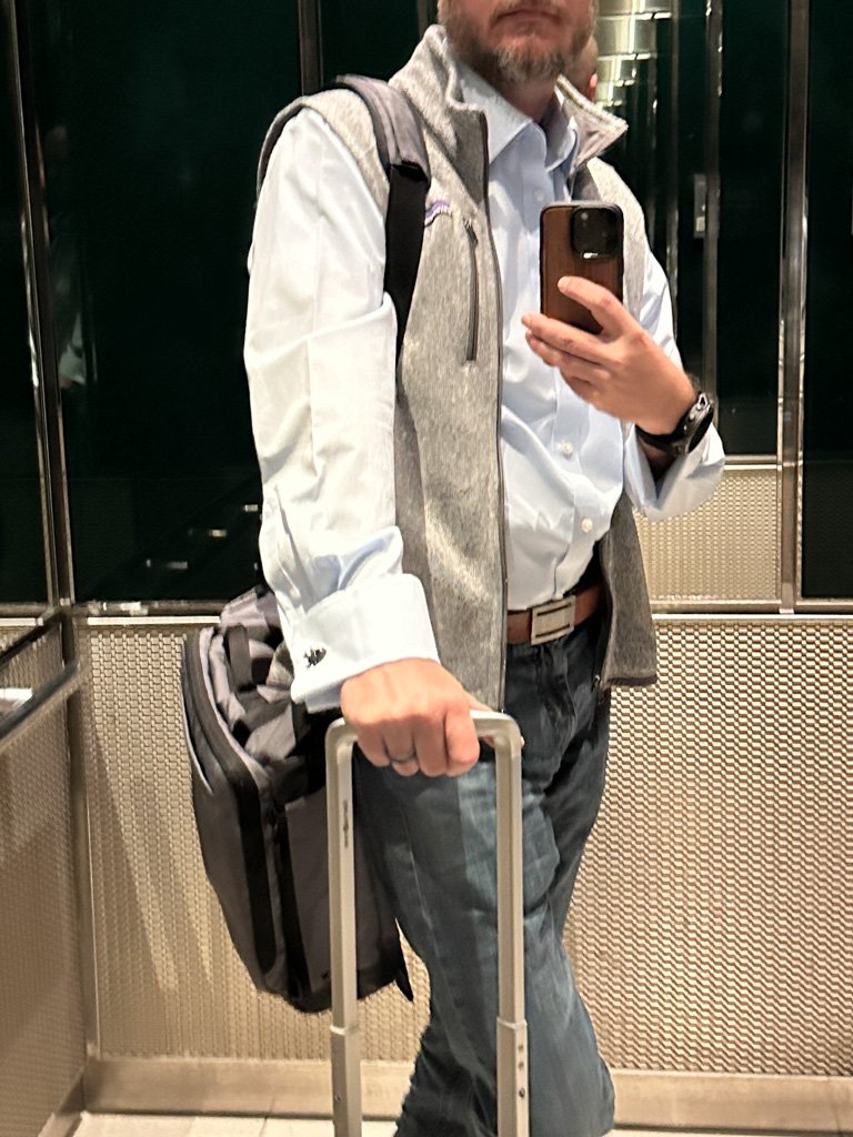 Stefan with his Timbuk2 messenger riding on a roller bag in a hotel elevator