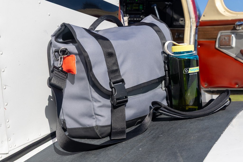 Timbuk2 messenger bag with a Nalgene bottle in the side pocket on the Piper Cherokee wing